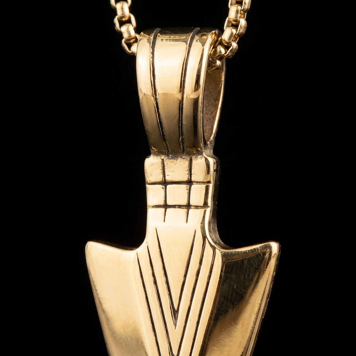 Macro close-up of the Arrow Gold pendant in 316L stainless steel, Outlaws Amsterdam